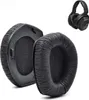 A close-up view of two black ear pads for headphones, with a pair of black headphones in the background. Produktbild-Vorschau