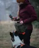 A person is training a dog outdoors with a toy and a hip pack. Produktbild-Vorschau
