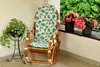 A rocking chair with cushions on a balcony with plants and flowers. Anteprima dell’immagine prodotto