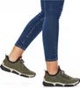 A person wearing blue jeans and green sneakers. Produktbild-Vorschau