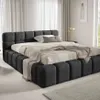 A modern bedroom with a large upholstered bed. Produktbild-Vorschau