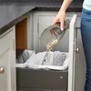 A person is emptying a handheld vacuum cleaner into a trash can. Anteprima dell’immagine prodotto