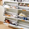 A white shoe cabinet with multiple shelves, each holding pairs of shoes. Produktbild-Vorschau