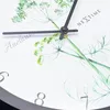 A close-up view of a wall clock with a floral design and visible numbers. Náhled obrázku produktu