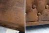 A close-up view of the textured brown upholstery of a Chesterfield armchair, showing the button tufting detail. Náhled obrázku produktu