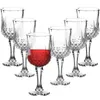 A set of six clear wine glasses with a diamond pattern on the lower half of the bowl, arranged on a white background. One glass in the foreground is filled with red wine. Podgląd zdjęcia produktu
