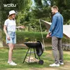 A couple is enjoying a barbecue in a park with a tent in the background. Produktbild-Vorschau