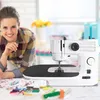 A woman is smiling and leaning over a sewing machine with various sewing supplies on a table. Produktbild-Vorschau