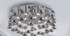 A close-up view of a modern chrome chandelier with multiple reflective, bulbous elements hanging from a circular ceiling mount. Podgląd zdjęcia produktu