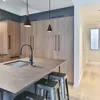 A modern kitchen island with pendant lights and stools. Anteprima dell’immagine prodotto