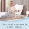 A woman is sitting on a bed next to a bed rail. Produktbild-Vorschau