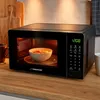 A black microwave oven with food inside, placed on a wooden countertop. Anteprima dell’immagine prodotto