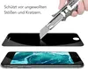 A hand is using a utility knife to demonstrate the scratch resistance of a screen protector placed over a smartphone screen. Produktbild-Vorschau