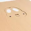 A close-up view of a wooden table with a carved-out design of a cartoonish animal face. Produktbild-Vorschau