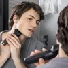 A young man is shaving his neck in front of a mirror. Produktbild-Vorschau