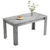 A rectangular dining table with a marble-like gray surface and fluted legs, set against a white background. A small bowl of fruit and a vase with a plant are placed on the table. Anteprima dell’immagine prodotto