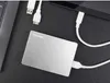 A silver Toshiba external hard drive is connected to a laptop and a tablet with USB cables. Produktbild-Vorschau