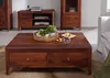 A living room setting with wooden furniture, including a coffee table in the foreground. Produktbild-Vorschau