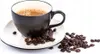 A dark brown coffee cup filled with coffee and foam sits on a white saucer, surrounded by coffee beans. Voir les images du produit