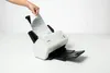 A hand is inserting a document into a Brother scanner. Voir les images du produit