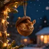 A cute fawn ornament sleeps inside an acorn, hanging from a decorated Christmas tree with lights. Produktbild-Vorschau