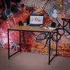 A desk with a laptop, speakers, and a plant against a graffiti-covered wall. Náhľad obrázku produktu