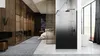 A modern bedroom with an attached bathroom, featuring a shower enclosure and a large window with a view. Anteprima dell’immagine prodotto