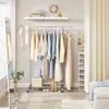 A clothing rack filled with dresses and tops, a shelf with accessories, and a mirror in a room. Podgląd zdjęcia produktu