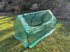 A green plastic greenhouse is set up on a grassy lawn with some bare bushes and trees in the background. Náhľad obrázku produktu