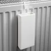 A white ceramic radiator humidifier is attached to a white radiator, with steam rising from it. Produktbild-Vorschau