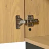 A close-up view of a cabinet hinge on a wooden surface. Anteprima dell’immagine prodotto