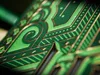 A close-up of a green and gold patterned surface, possibly a playing card or book cover. Náhled obrázku produktu