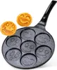 A frying pan with seven smiley face molds, with two smiley face pancakes next to it. Náhled obrázku produktu