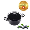 A black pot with a glass lid and a gold seal indicating "Swiss Quality" is shown against a white background. A few blueberries and leaves are placed in the bottom right corner. Náhľad obrázku produktu
