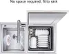A compact dishwasher next to a sink, with dishes inside. Podgląd zdjęcia produktu