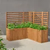 A wooden planter with plants on a paved surface against a gray wall. Anteprima dell’immagine prodotto