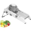 A white and gray mandoline slicer is shown on a white background, with a small pile of fresh vegetables in the bottom left corner. Produktbild-Vorschau