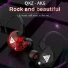 A close-up marketing image of two QKZ AK6 in-ear headphones, one red and one black, against a dark, textured background with purple and pink abstract light effects. Produktbild-Vorschau