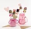 Decorated marshmallows on sticks in jars, with heart-shaped decorations and sprinkles. Produktbild-Vorschau