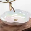 A close-up shot of a pearlescent vessel sink with a gold faucet. Náhľad obrázku produktu