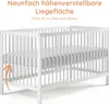 A white baby crib with a mattress, showing the adjustable height feature. Produktbild-Vorschau