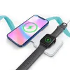 A smartphone and a smartwatch are placed on a white wireless charging pad, both indicating charging status with a green lightning bolt icon. Produktbild-Vorschau