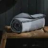 A rolled-up blanket on a wooden surface. Náhled obrázku produktu