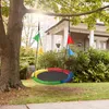 A colorful nest swing hangs from a tree branch in a yard, with a house in the background. Náhled obrázku produktu