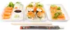 A top-down view of a sushi platter with various types of sushi and sashimi, accompanied by chopsticks and a wrapper. Produktbild-Vorschau