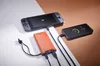 A power bank is charging a Nintendo Switch and a smartphone. Voir les images du produit