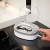 A hand presses a button on an ultrasonic cleaner with glasses inside. Produktbild-Vorschau