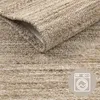 A close-up view of a textured rug, with a portion folded back to reveal the underside. A circular icon indicating washability is present in the lower right corner. Produktbild-Vorschau