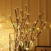 A decorative arrangement of LED-lit branches in a geometric vase. Anteprima dell’immagine prodotto