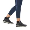 A person wearing blue jeans and black high-top boots is shown walking against a white background. Voir les images du produit